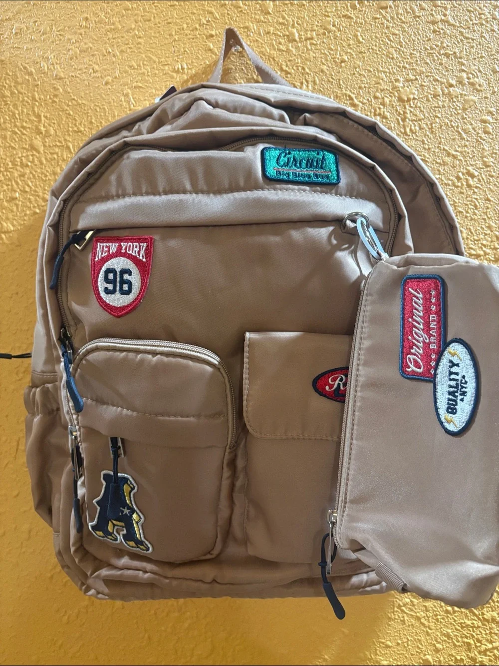 Beige Men's Backpack with Patch Accents and Matching Pouch